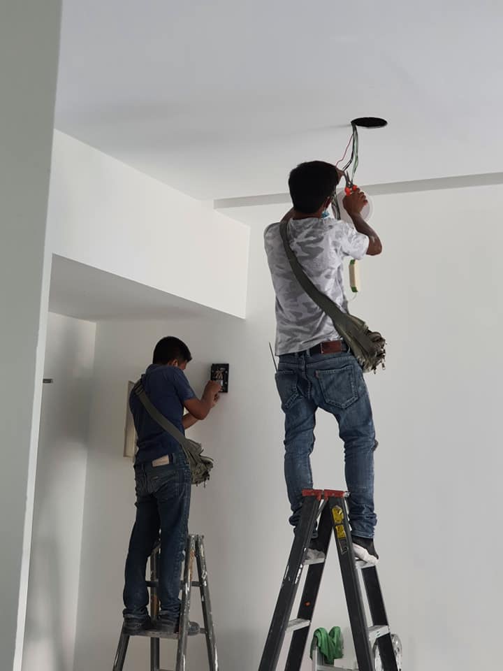 In-house workers performing wiring works for the installation of lighting